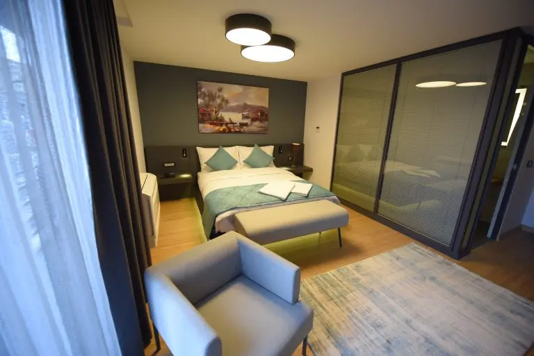 Deluxe Suit: çift kişilik yatak, koltuk ve cam bölmeli banyo